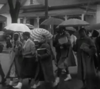 women with umbrellas crossing street