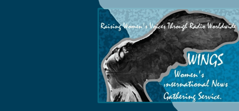 The image is a banner for WINGS (Women’s International News Gathering Service). It features an artistic depiction of a woman with wings, symbolizing the goddess Nike. The woman is shown in black and white against a textured blue and teal background, giving the image a vintage, yet powerful feel. In the top left corner, the text reads, “Raising Women’s Voices Through Radio Worldwide” in a handwritten-style font. On the right side of the image, the acronym “WINGS” is displayed in large, bold, white letters. Below it, the full name, “Women’s International News Gathering Service,” is written in a smaller, script-like font. The overall design conveys a sense of strength, movement, and global outreach, aligning with the mission of WINGS to amplify women’s voices through radio.